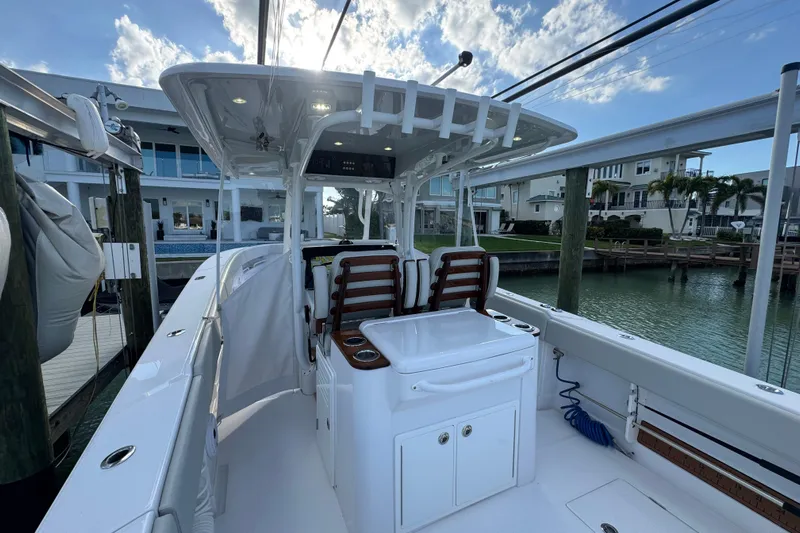 High Steaks Yacht Photos Pics 2024 Jupiter 38 HFS boat interior with seating and helm, docked by waterfront homes.