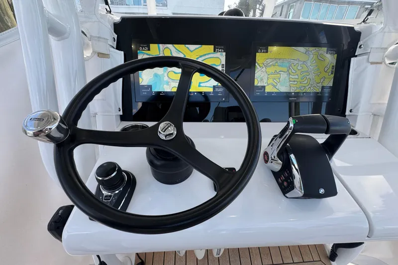 High Steaks Yacht Photos Pics 2024 Jupiter 38 HFS helm with steering wheel, dual navigation screens, and throttle controls.