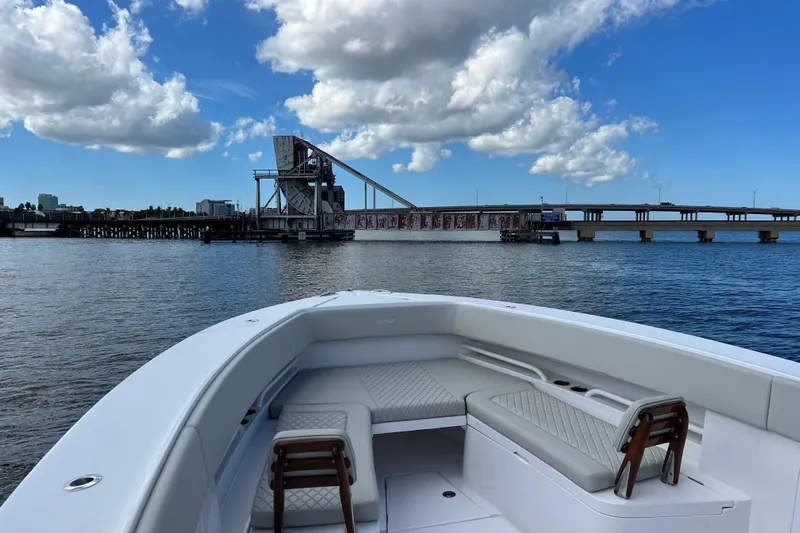 High Steaks Yacht Photos Pics 2024 Jupiter 38 HFS boat on water, bridge and cloudy sky in background.