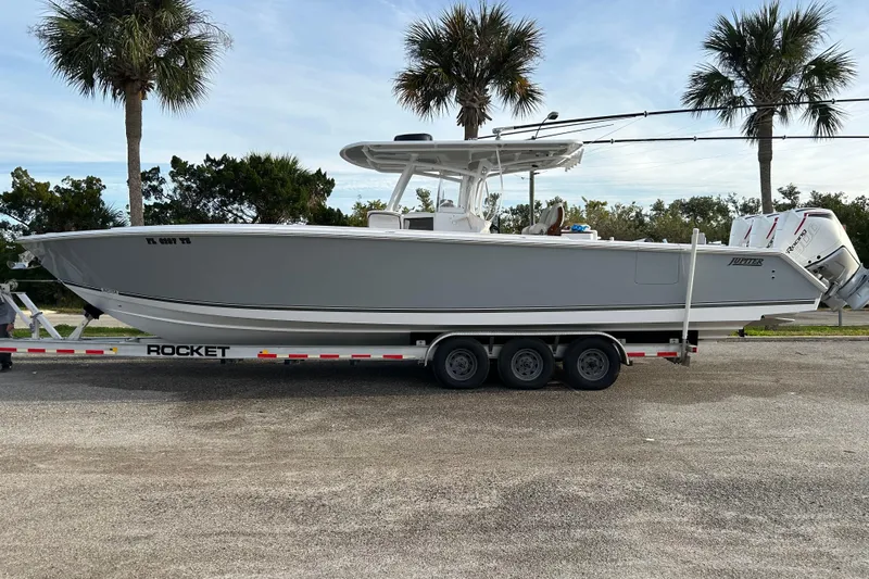High Steaks Yacht Photos Pics 2024 Jupiter 38 HFS boat on trailer, parked with palm trees in the background.