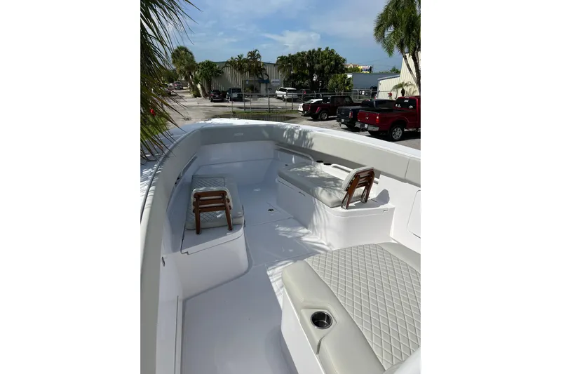 High Steaks Yacht Photos Pics 2024 Jupiter 38 HFS boat interior with seating, docked near palm trees and parked vehicles.