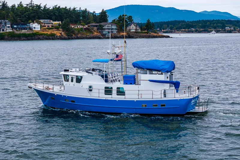 Single Star Yacht Photos Pics 1978 Hidden Harbor Custom Trawler cruising on scenic waters with coastal homes in the background.