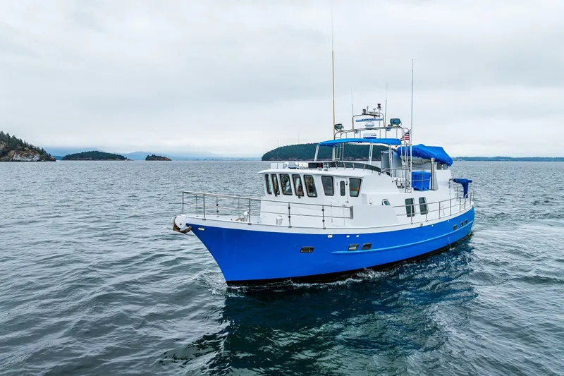 Single Star Yacht Photos Pics Blue and white 1978 Hidden Harbor Custom Trawler cruising on open water.