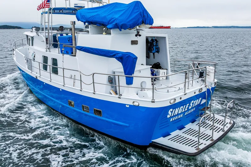 Single Star Yacht Photos Pics Blue 1978 Hidden Harbor Custom Trawler cruising on open water, named "Single Star" from Kodiak, Alaska.