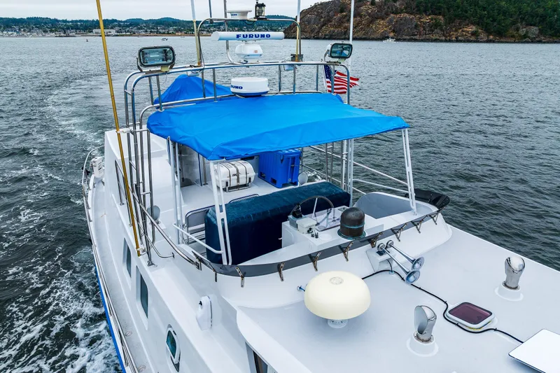 Single Star Yacht Photos Pics 1978 Hidden Harbor Custom Trawler with blue canopy cruising on scenic waters.