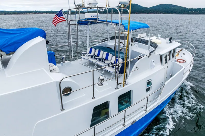 Single Star Yacht Photos Pics 1978 Custom Trawler cruising on water, featuring deck chairs and American flag.