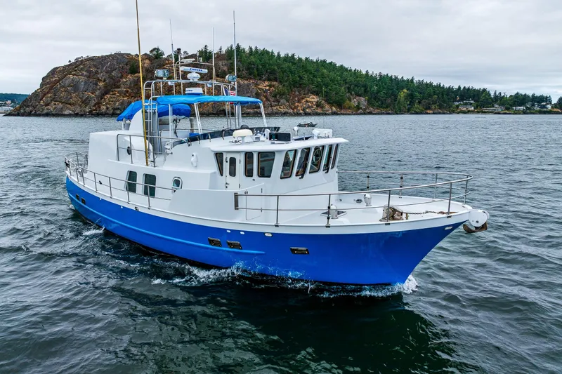Single Star Yacht Photos Pics 1978 Hidden Harbor Custom Trawler cruising in scenic waters near rocky shoreline.