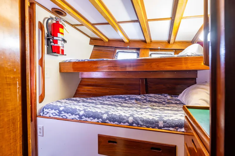 Single Star Yacht Photos Pics Cozy cabin interior of 1978 Hidden Harbor Custom Trawler with wooden bunk beds and fire extinguisher.