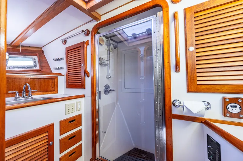 Single Star Yacht Photos Pics 1978 Hidden Harbor Custom Trawler bathroom with wooden cabinetry and modern shower.