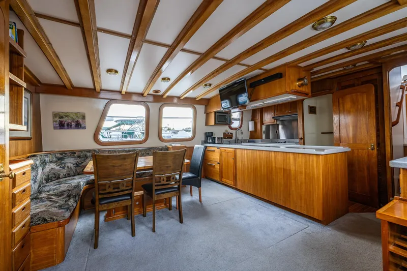 Single Star Yacht Photos Pics Interior of 1978 Hidden Harbor Custom Trawler with wooden cabinetry and dining area.