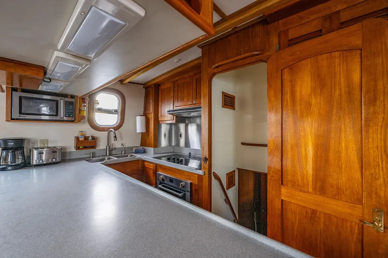 Single Star Yacht Photos Pics 1978 Hidden Harbor Custom Trawler kitchen with wooden cabinetry and modern appliances.