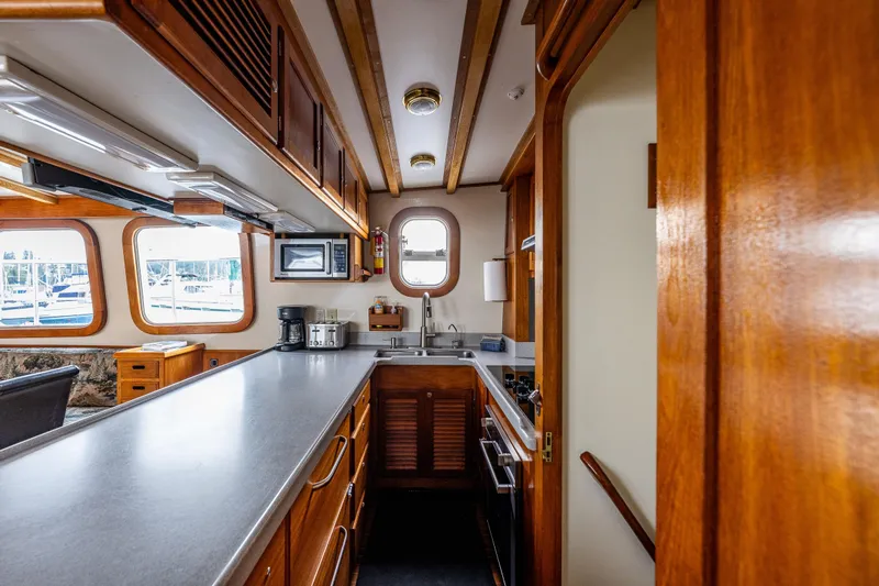 Single Star Yacht Photos Pics 1978 Hidden Harbor Custom Trawler kitchen with wooden cabinetry and modern appliances.