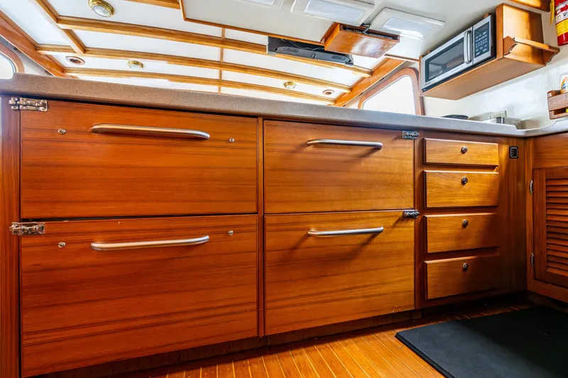 Single Star Yacht Photos Pics 1978 Hidden Harbor Custom Trawler kitchen with wooden cabinets and modern appliances.