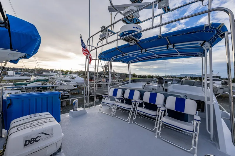 Single Star Yacht Photos Pics 1978 Hidden Harbor Custom Trawler with blue canopy and seating, docked at marina.