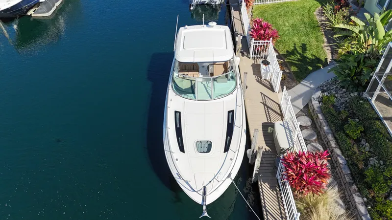  Yacht Photos Pics Aerial view of a 2016 Sea Ray 350 Sundancer docked by a lush garden.