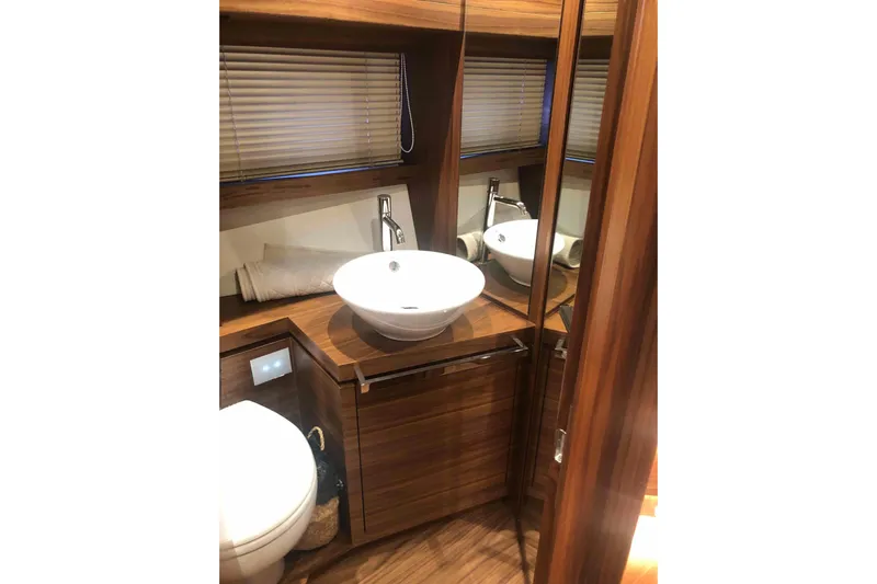  Yacht Photos Pics Luxurious bathroom interior of 2020 Sundeck Yachts 580 with modern fixtures and wood finish.