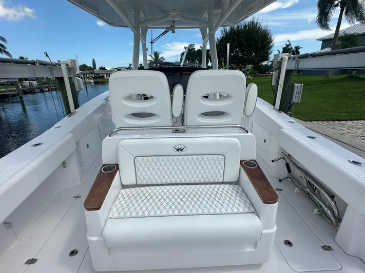  Yacht Photos Pics 2024 Southport 30 FE boat interior with white seating and wooden accents, docked by a canal.