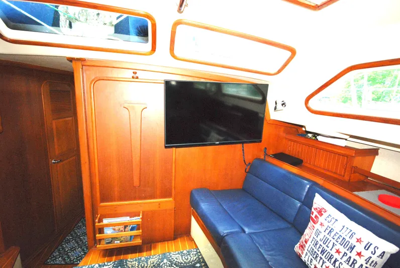Priva Sea Yacht Photos Pics Interior of 2003 Island Packet 485 yacht with blue seating and mounted TV.