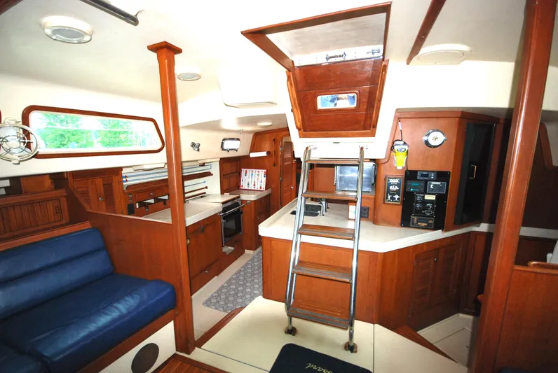 Priva Sea Yacht Photos Pics Interior of 2003 Island Packet 485 yacht with wooden cabinetry and blue seating.