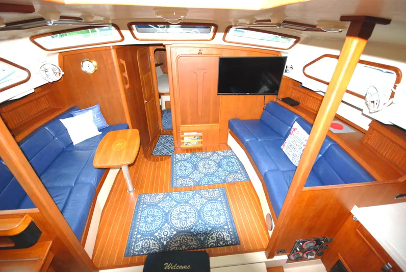 Priva Sea Yacht Photos Pics Luxurious 2003 Island Packet 485 yacht interior with blue seating and wooden finishes.