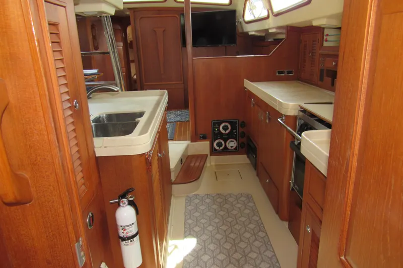 Priva Sea Yacht Photos Pics Interior of 2003 Island Packet 485 yacht, featuring a well-equipped kitchen and wooden cabinetry.