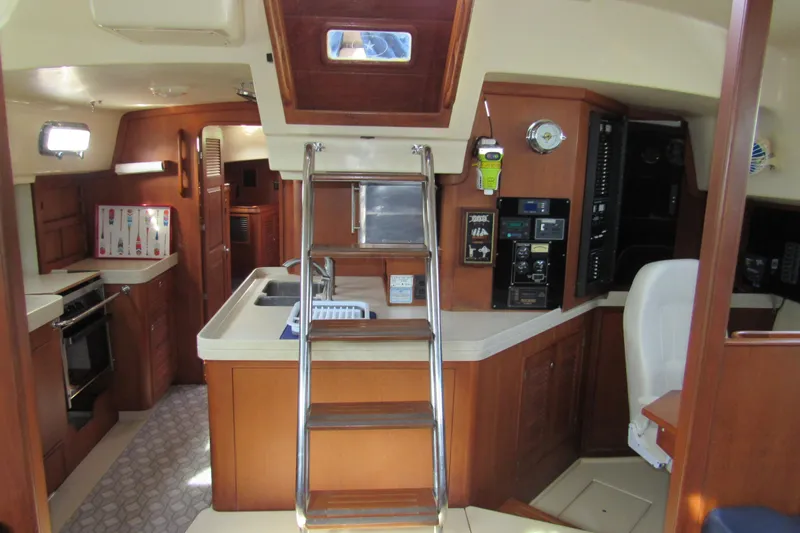 Priva Sea Yacht Photos Pics Interior of 2003 Island Packet 485 yacht, featuring kitchen and navigation area with wooden cabinetry.