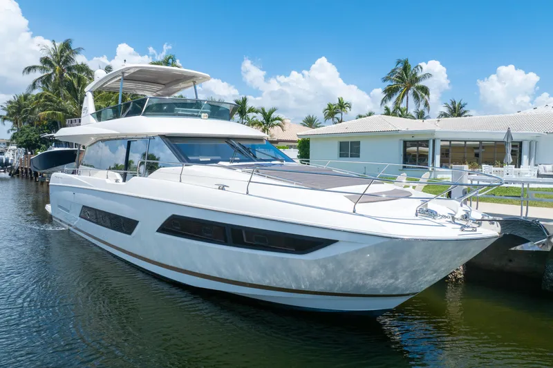  Yacht Photos Pics Luxury 2018 Prestige 680 yacht docked by waterfront homes, under clear blue skies.