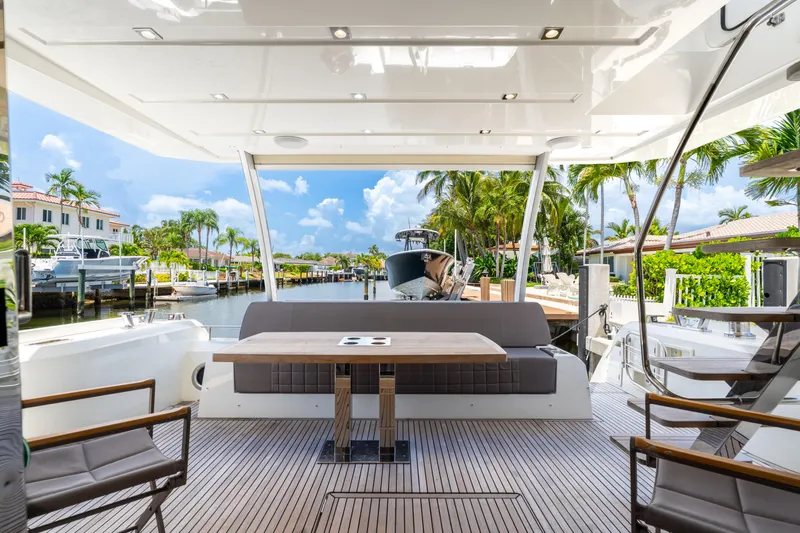  Yacht Photos Pics Luxurious 2018 Prestige 680 yacht deck with seating, table, and scenic waterfront view.