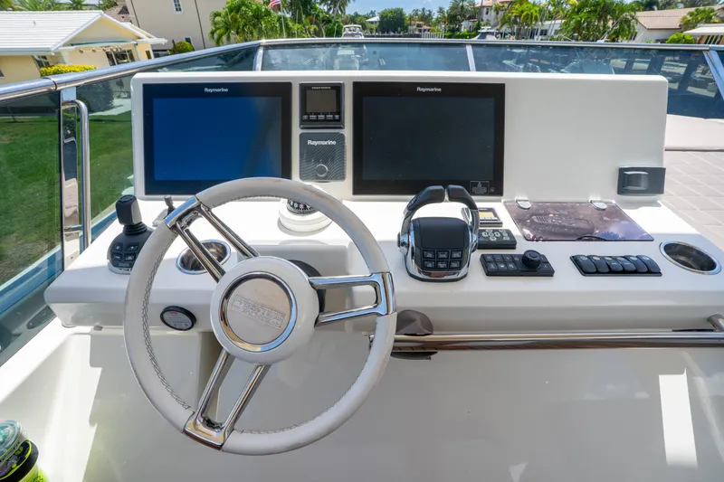  Yacht Photos Pics Control panel of a 2018 Prestige 680 yacht with steering wheel and navigation screens.