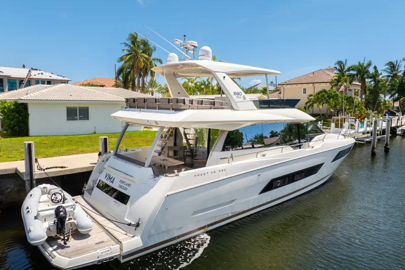  Yacht Photos Pics Luxurious 2018 Prestige 680 yacht docked in a sunny waterfront setting.