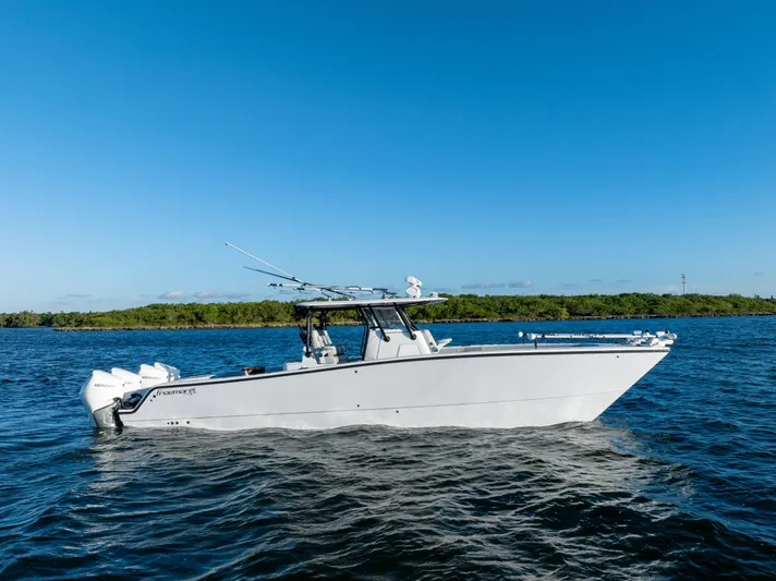  Yacht Photos Pics 2020 Freeman 37 VH boat on water, clear blue sky, lush green shoreline.