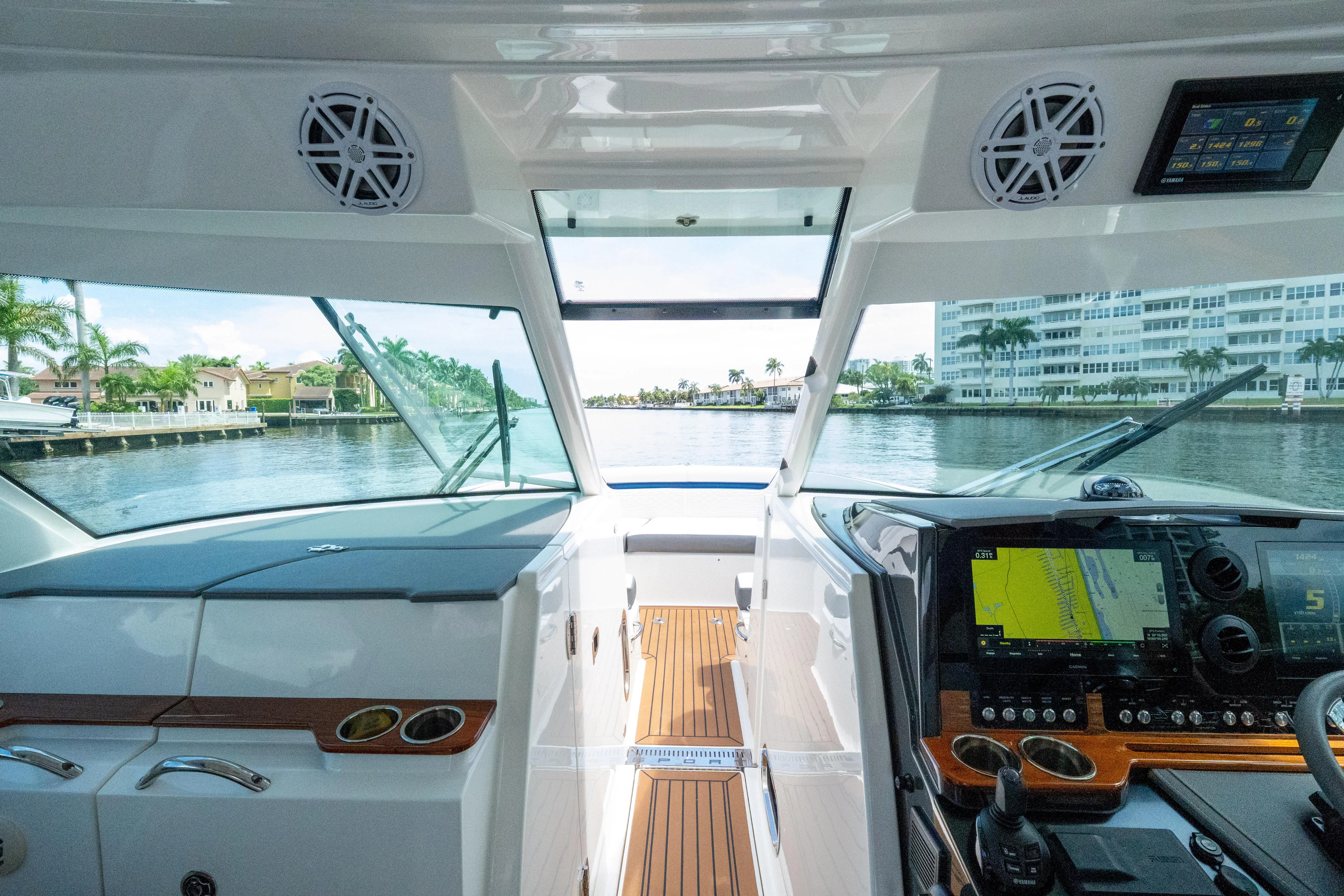  Yacht Photos Pics Interior view of 2021 Tiara Sport 38 LX yacht cockpit with navigation screens and waterfront scenery.
