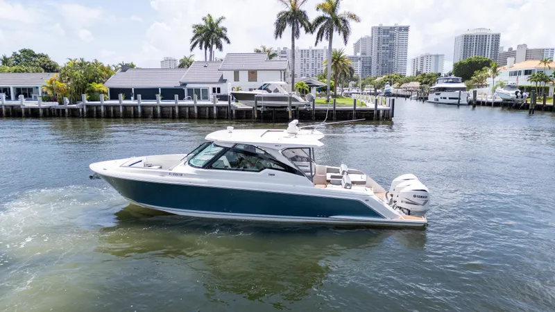  Yacht Photos Pics 2021 Tiara Sport 38 LX boat cruising in a scenic waterfront area.