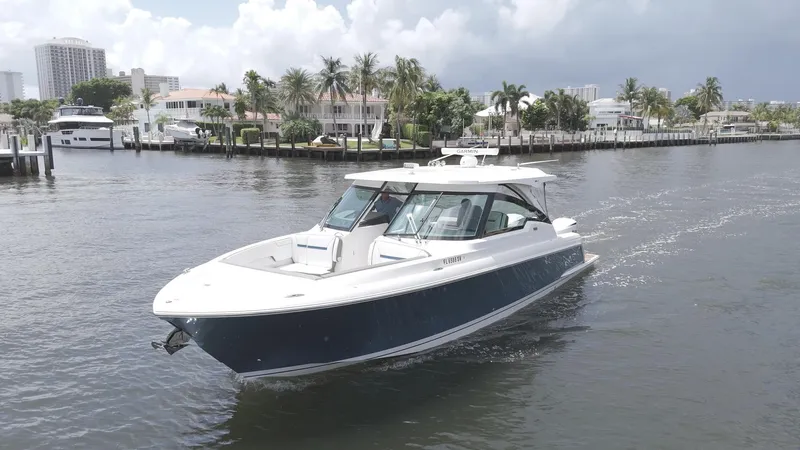  Yacht Photos Pics 2021 Tiara Sport 38 LX boat cruising on a scenic waterway with palm trees.