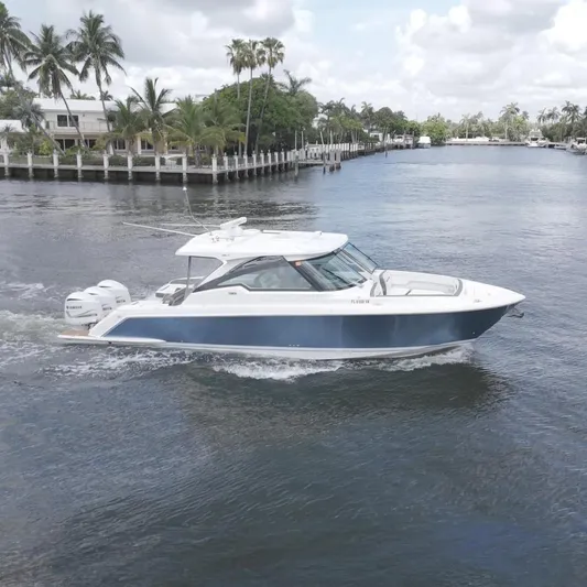  Yacht Photos Pics 2021 Tiara Sport 38 LX cruising on a scenic waterway with palm trees.