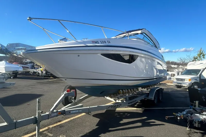  Yacht Photos Pics 2024 Regal 28 Express boat on trailer in parking lot under clear blue sky.