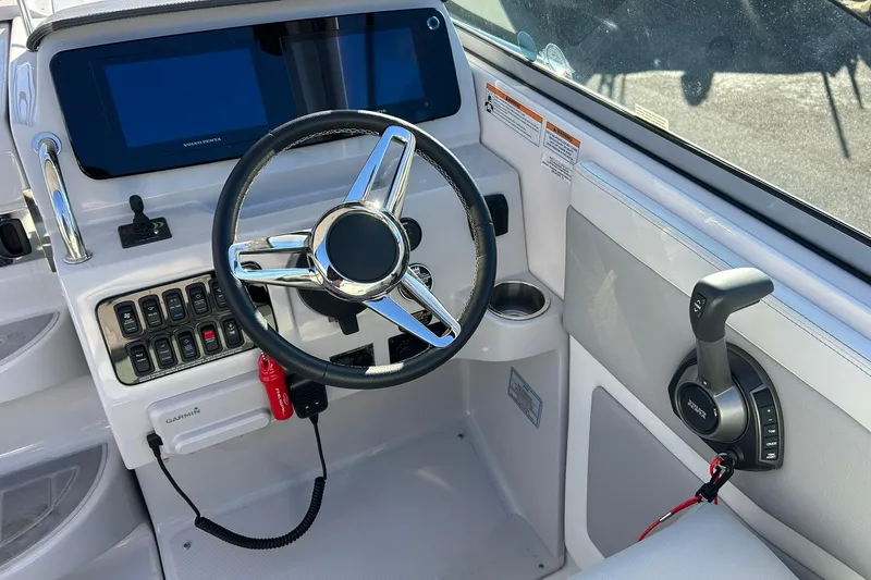  Yacht Photos Pics 2024 Regal 28 Express boat helm with steering wheel and control panel.