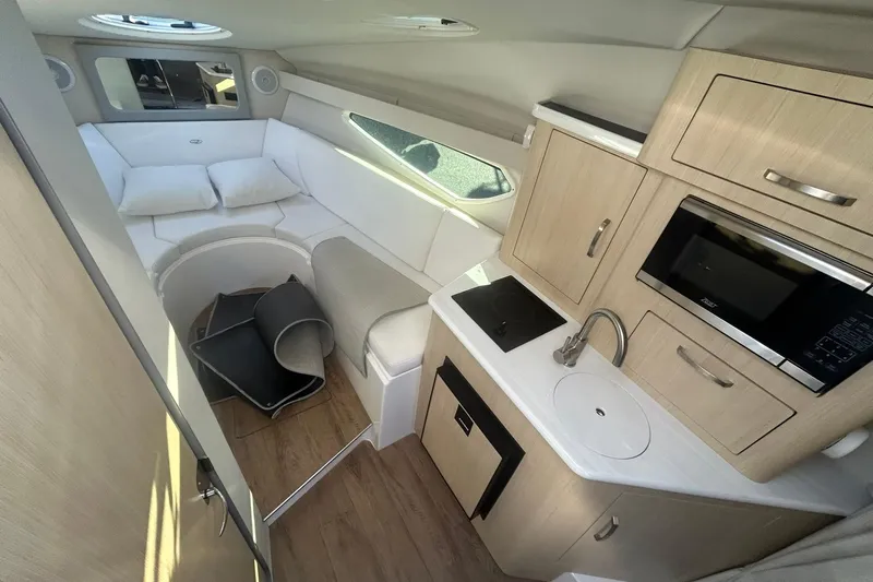  Yacht Photos Pics 2024 Regal 28 Express cabin interior with kitchenette, seating, and modern amenities.