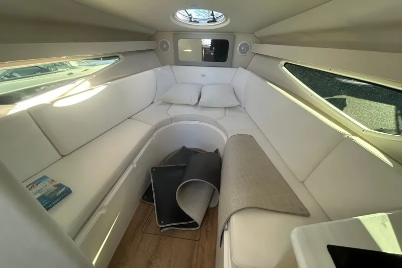  Yacht Photos Pics 2024 Regal 28 Express cabin interior with white seating and natural light.