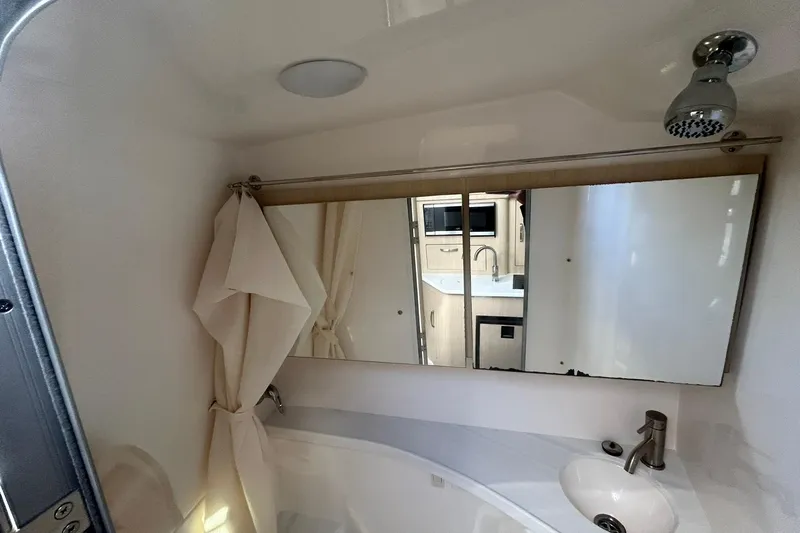  Yacht Photos Pics 2024 Regal 28 Express bathroom with mirror, sink, and showerhead.