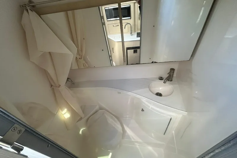  Yacht Photos Pics 2024 Regal 28 Express bathroom with sink, mirror, and shower curtain.