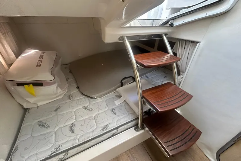  Yacht Photos Pics 2024 Regal 28 Express cabin interior with wooden steps and mattress.