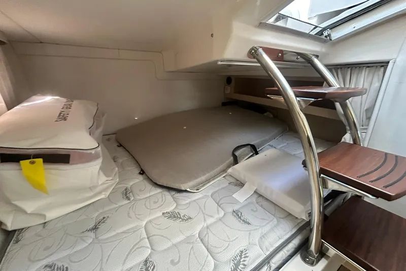  Yacht Photos Pics 2024 Regal 28 Express cabin interior with mattress, storage, and wooden steps.