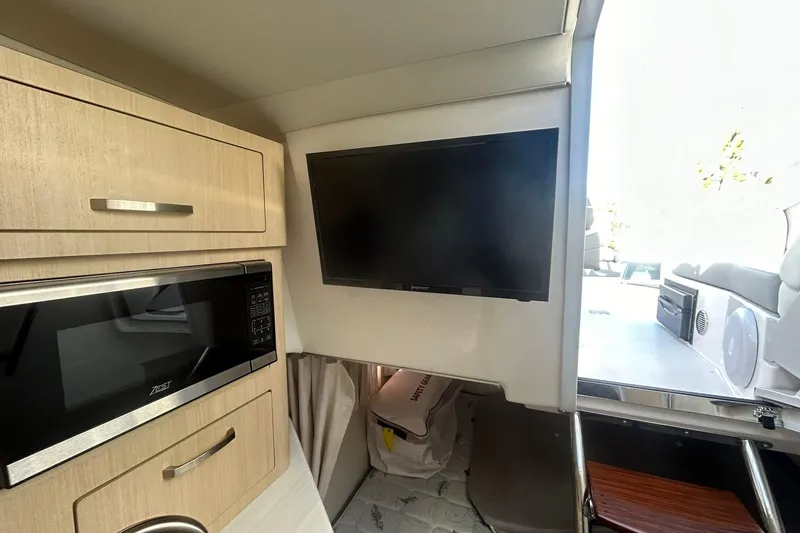  Yacht Photos Pics 2024 Regal 28 Express interior with TV, microwave, and cabinetry.