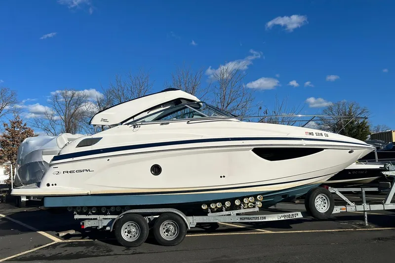  Yacht Photos Pics 2024 Regal 28 Express boat on trailer under clear blue sky.