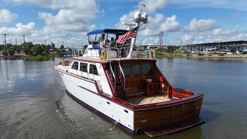 Liberty Belle Yacht Photos Pics 1980 Bertram 58 Convertible Custom yacht on calm water, featuring classic design and American flag.