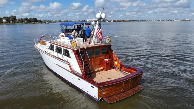 Liberty Belle Yacht Photos Pics 1980 Bertram 58 Convertible Custom yacht on calm water, featuring a spacious deck and American flag.