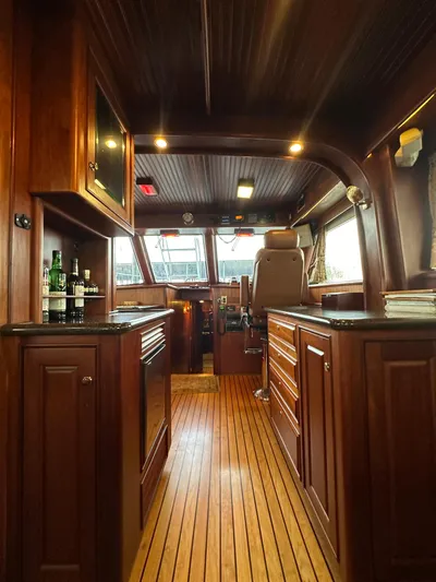 Liberty Belle Yacht Photos Pics Luxurious interior of a 2010 Bertram 58 Convertible yacht with wooden cabinetry and flooring.