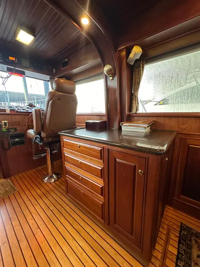 Liberty Belle Yacht Photos Pics Luxurious interior of a 2010 Bertram 58 Convertible yacht with wooden cabinetry and captain's chair.