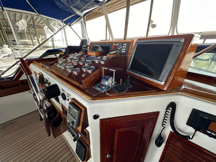 Liberty Belle Yacht Photos Pics 1980 Bertram 58 Convertible Custom yacht helm with navigation instruments and wooden paneling.